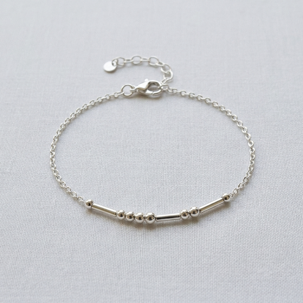The silver Morse code bracelet on pale linen