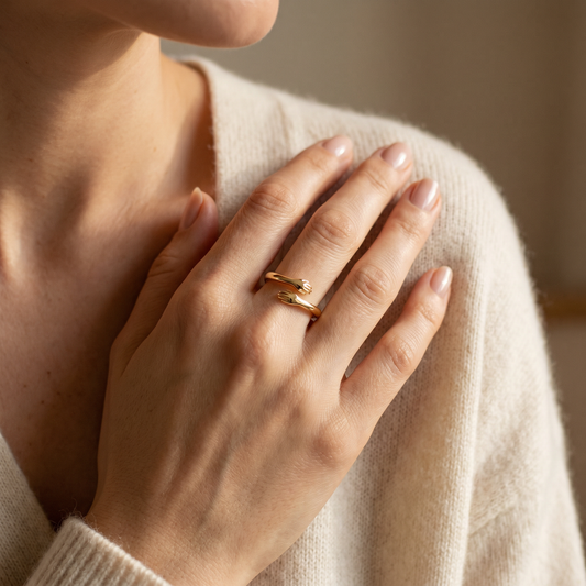 Woman wearing the dainty gold hug ring, two little arms hugging her finger