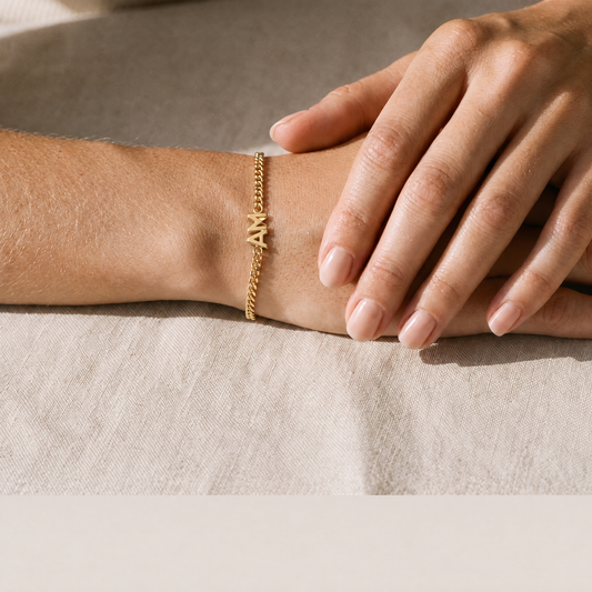 Yours & Mine gold initial bracelet worn on the wrist