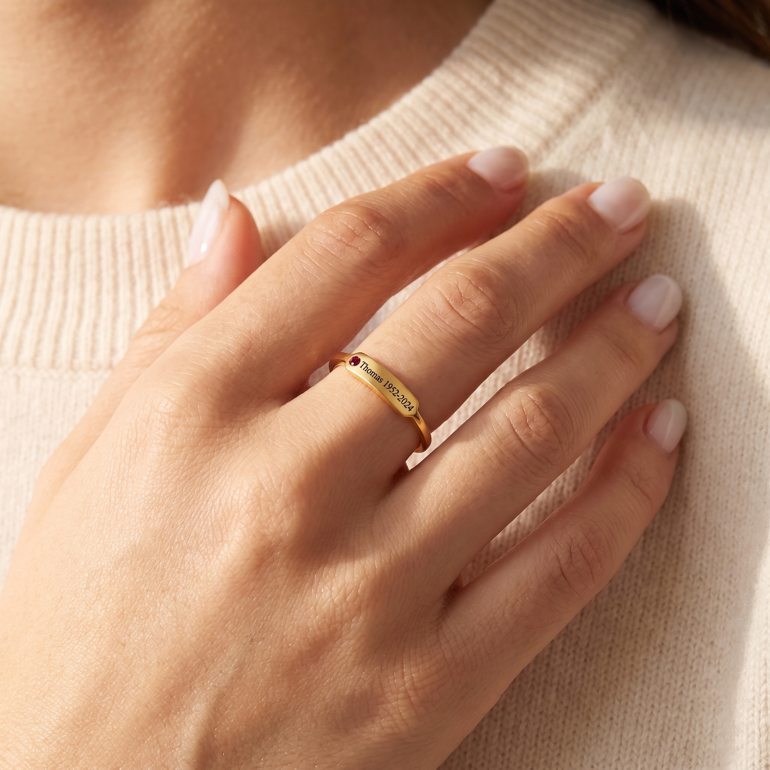 Gold custom name birthstone ring worn on a hand
