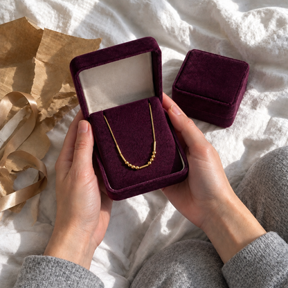 Unboxing the gold Morse code necklace in its plum velvet gift box