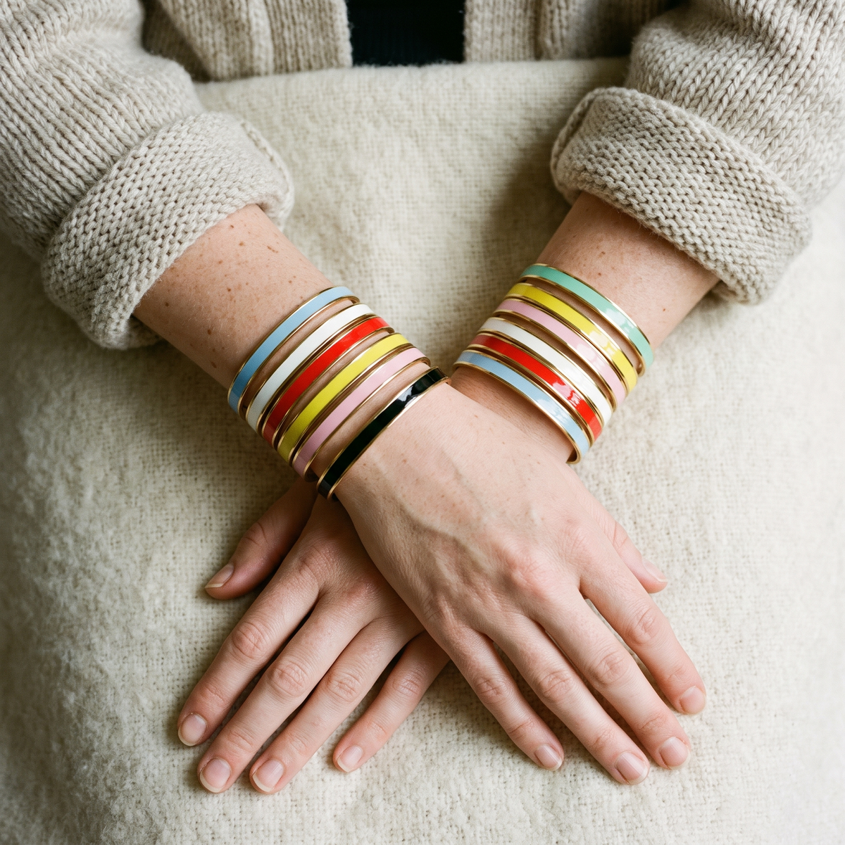 Stacks of enamel cuffs in every colour on two wrists
