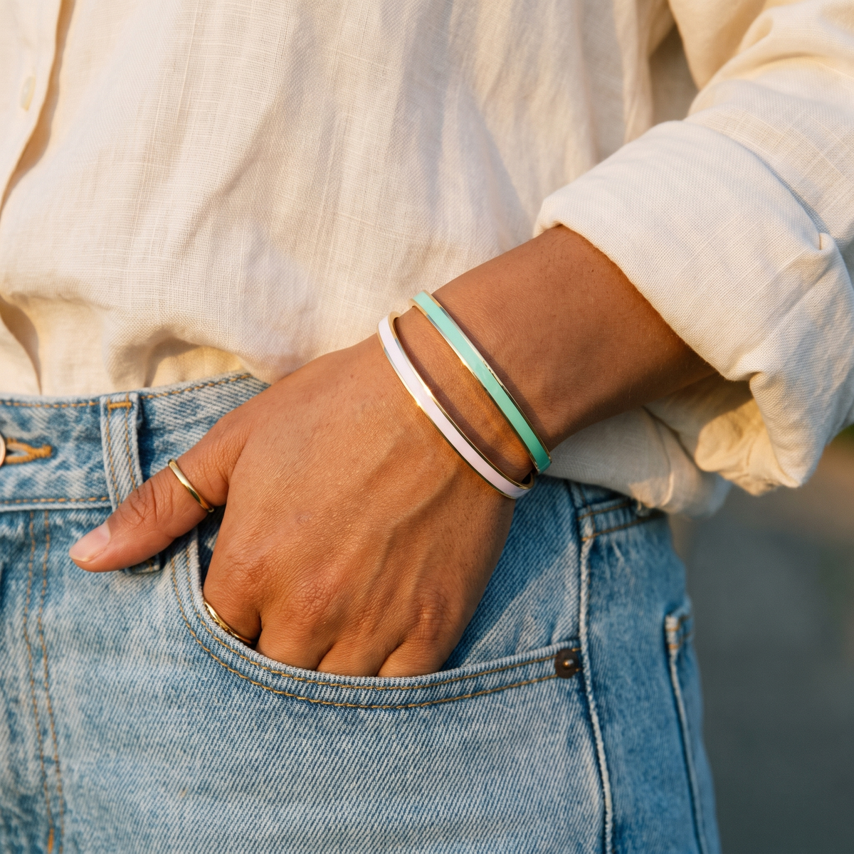 Sea green and chalk white cuffs worn with a hand in a jeans pocket