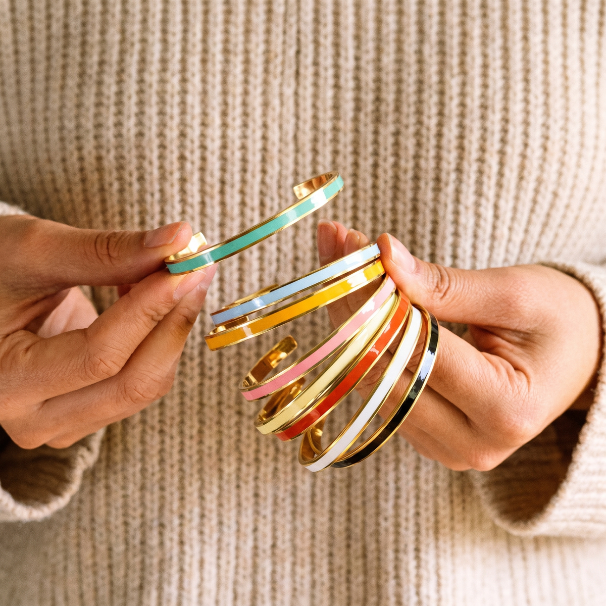Hands holding the seven cuff colours fanned out