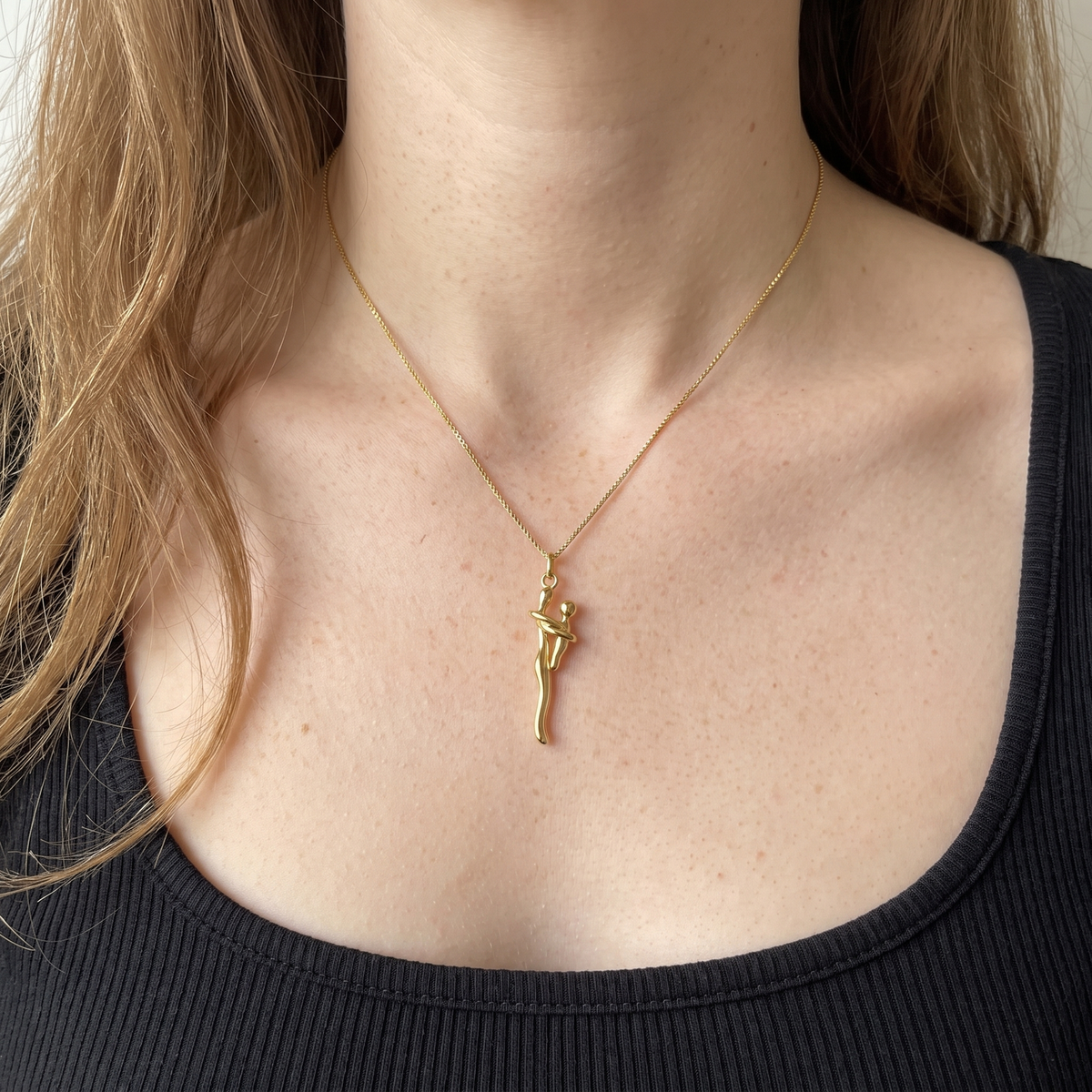 The all gold hug necklace worn with a black ribbed top