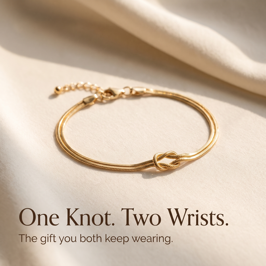 Gold Forever Knot bracelet laid on ivory linen with the words One Knot Two Wrists