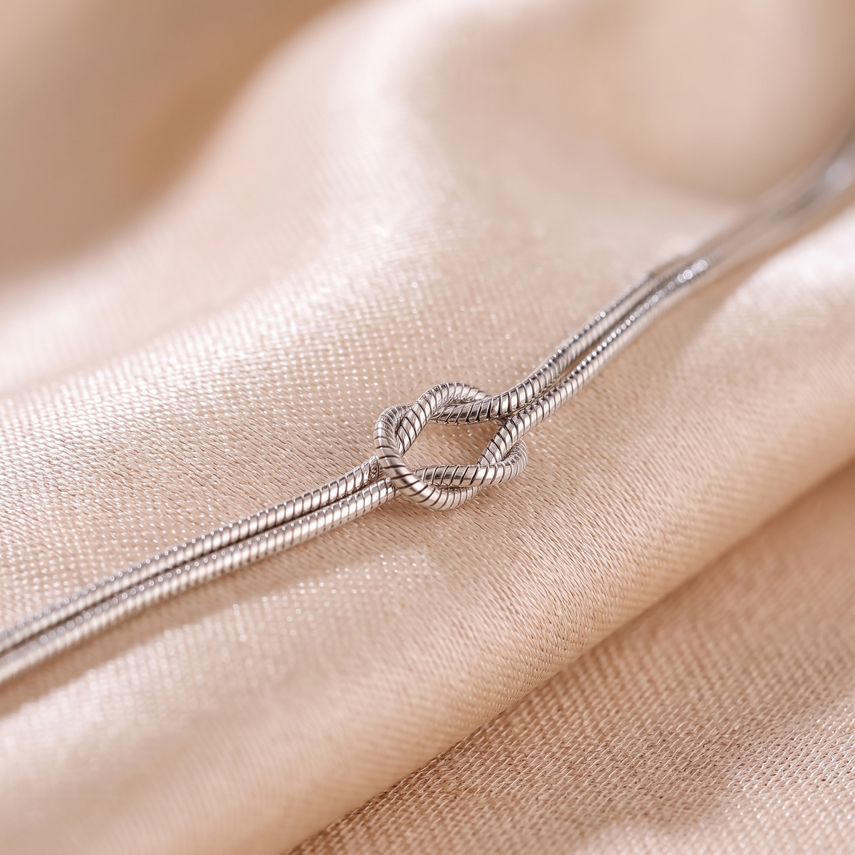 Macro view of the flat centre knot on the silver snake chain
