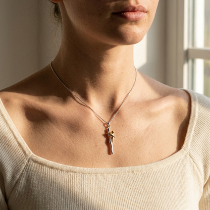 The silver and gold hug necklace worn with a cream knit top