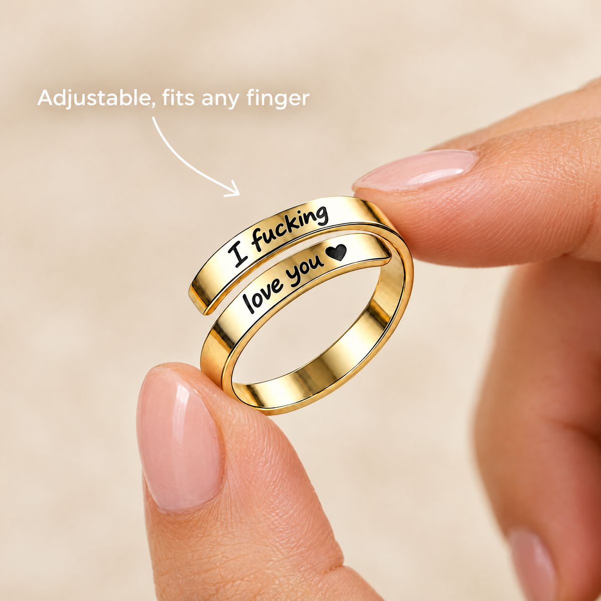 The gold ring held between two fingertips, adjustable to fit any finger