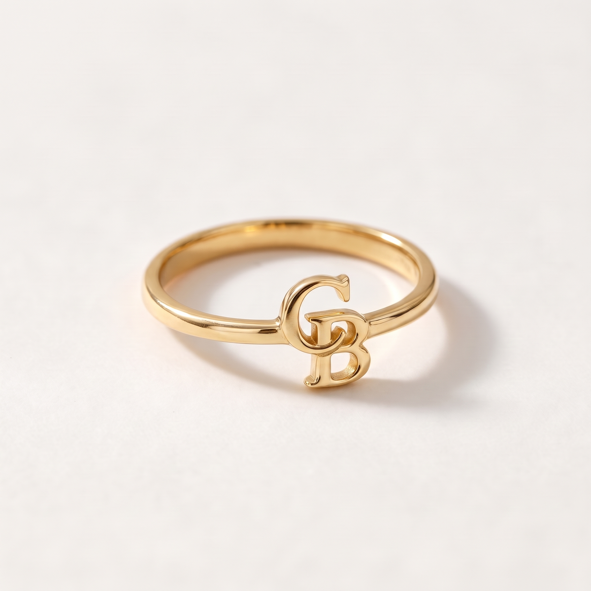 Gold ring with two interlocking serif initials