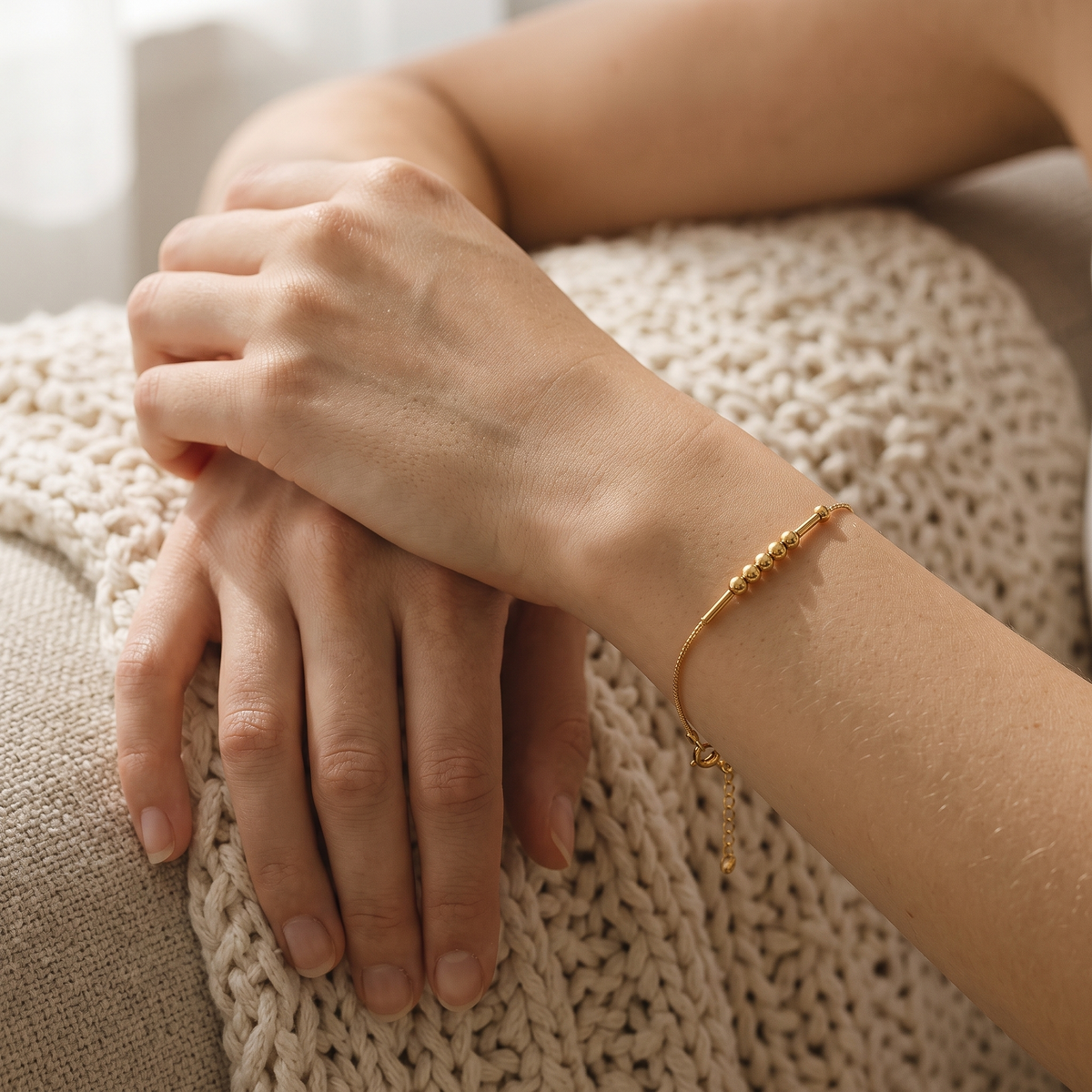 The gold Morse code chain bracelet worn on the wrist