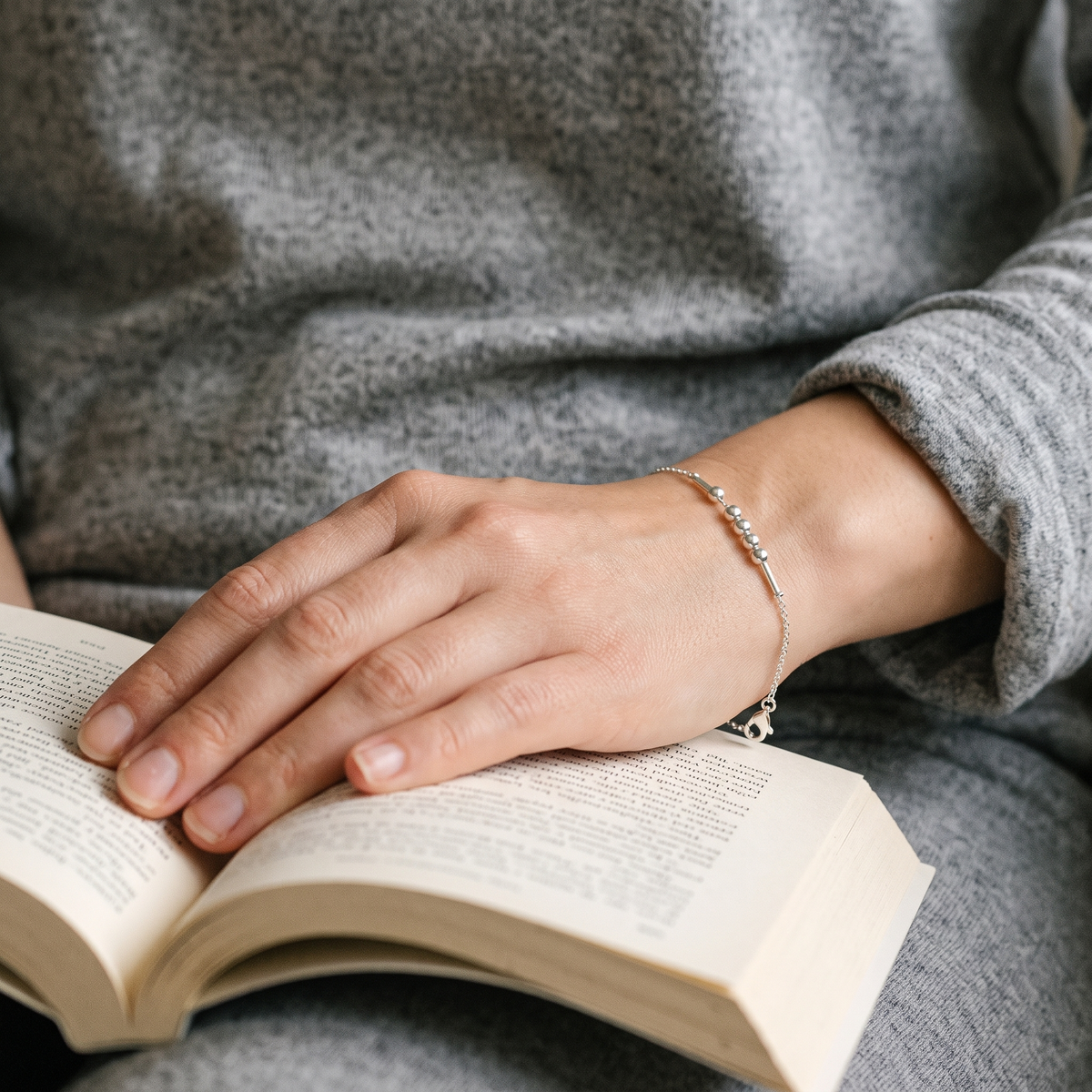 The silver Morse code chain bracelet worn while reading