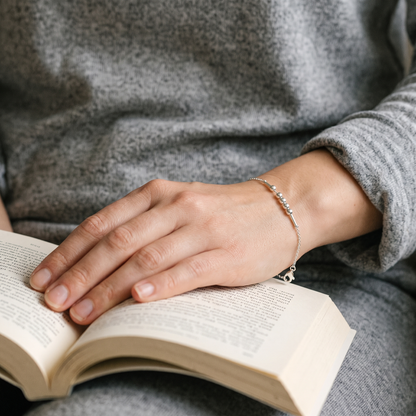The silver Morse code chain bracelet worn while reading