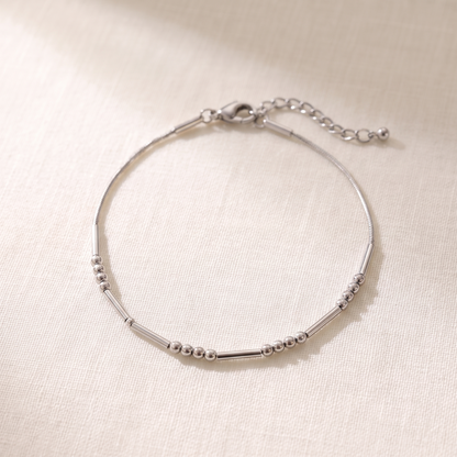 The silver Morse code chain bracelet on linen