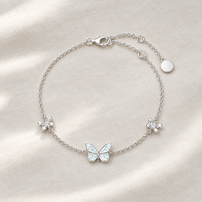 Silver butterfly bracelet with two crystal flowers on ivory linen