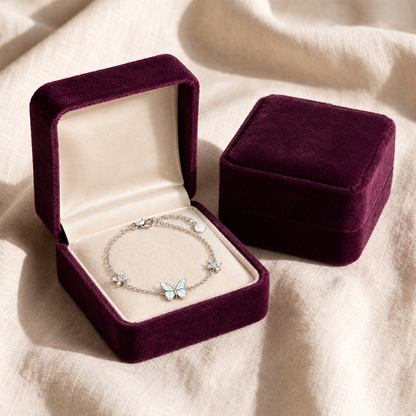The bracelet laid flat in its plum velvet gift box