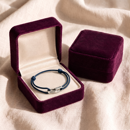 The bracelet laid flat in its plum velvet gift box