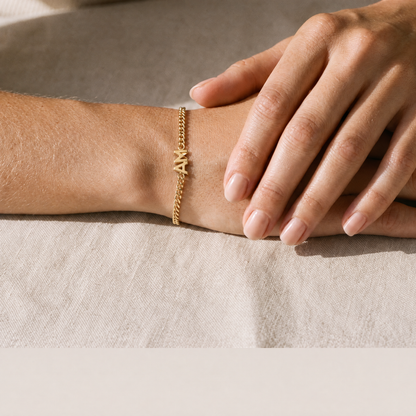 Yours & Mine gold initial bracelet worn on the wrist