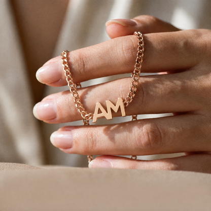 Rose gold Yours & Mine bracelet held between the fingers
