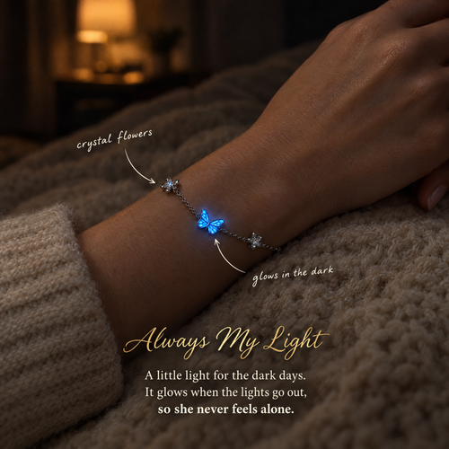 The butterfly bracelet on a wrist in a dark room, the enamel butterfly glowing blue