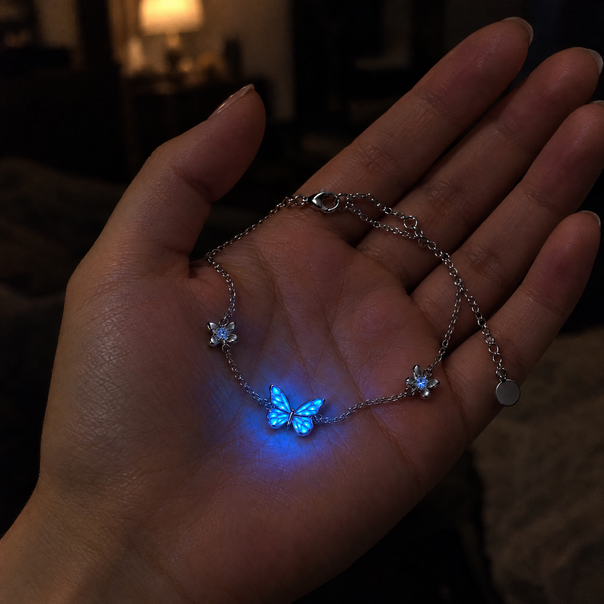 The butterfly bracelet resting in an open palm in the dark, the butterfly glowing blue