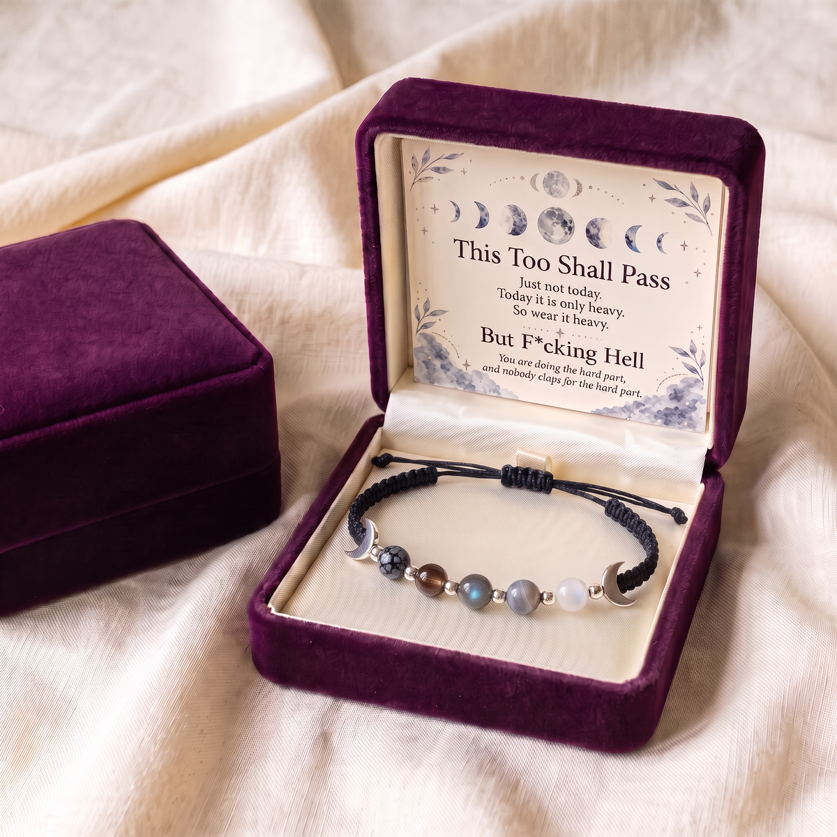 Black cord bracelet in an open plum gift box with the keepsake card