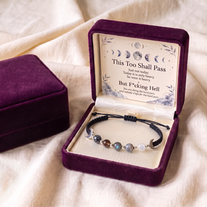 Black cord bracelet in an open plum gift box with the keepsake card